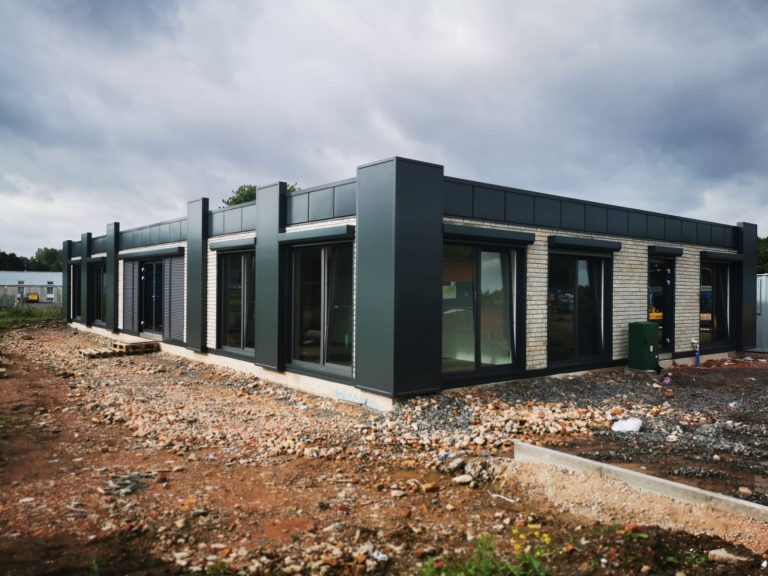 KC Modular Buildings MS Series Installation - Contemporary Commercial Design Premium modular building construction with dark exterior finish and floor-to-ceiling windows in progress