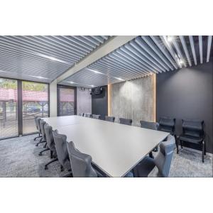 Modern ISO Frame modular office conference room with sleek white table, grey chairs, and industrial ceiling design