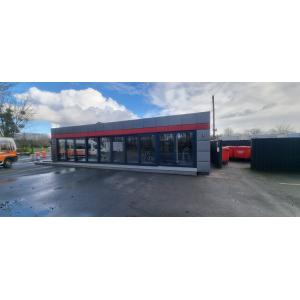 Modern modular restaurant building with grey exterior and red accent stripe