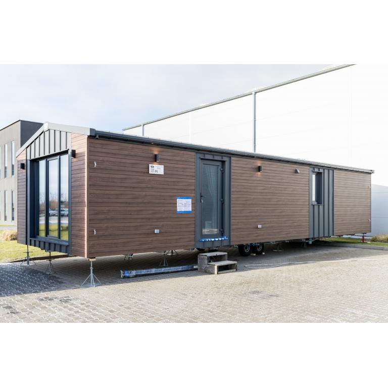 Side view of Maldives Lodge mobile home featuring brown composite cladding and service entrance