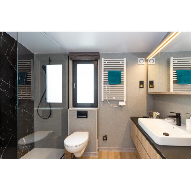 Modern mobile home bathroom with walk-in shower, heated towel rail, and contemporary fixtures