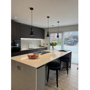 Marketing suite show kitchen with dark grey handleless cabinets, quartz worktops, integrated appliances, LED strip lighting and designer pendants by KC Modular Buildings