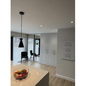 Marketing suite consultation area with fitted wardrobes, floor plan display boards, mirrored sliding doors, designer seating and quartz breakfast bar by KC Modular Buildings