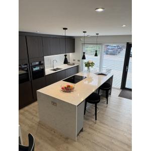 Contemporary marketing suite kitchen with dark grey timber-effect cabinets, white quartz island worktops, integrated appliances, LED lighting and designer pendants by KC Modular Buildings