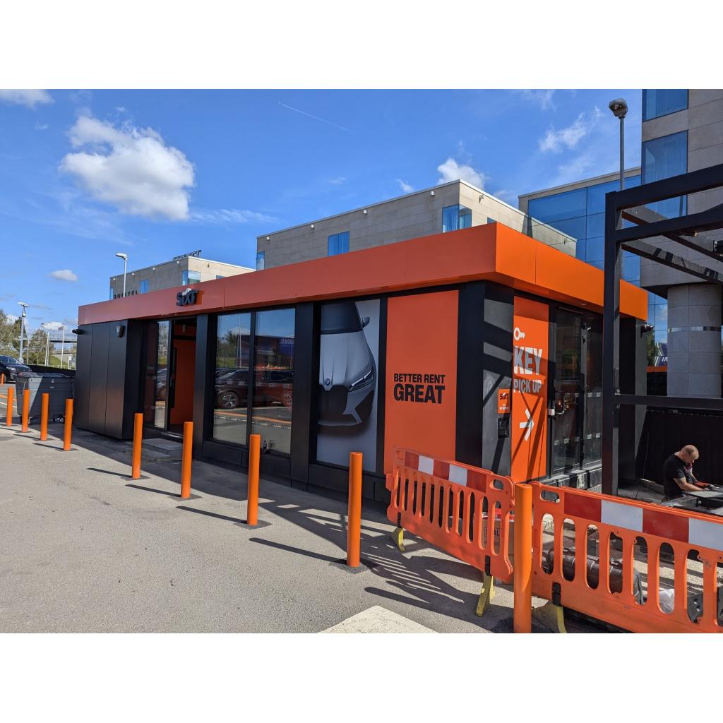 Part L compliant modular building with orange and grey cladding serving as SIXT car rental office in urban UK location