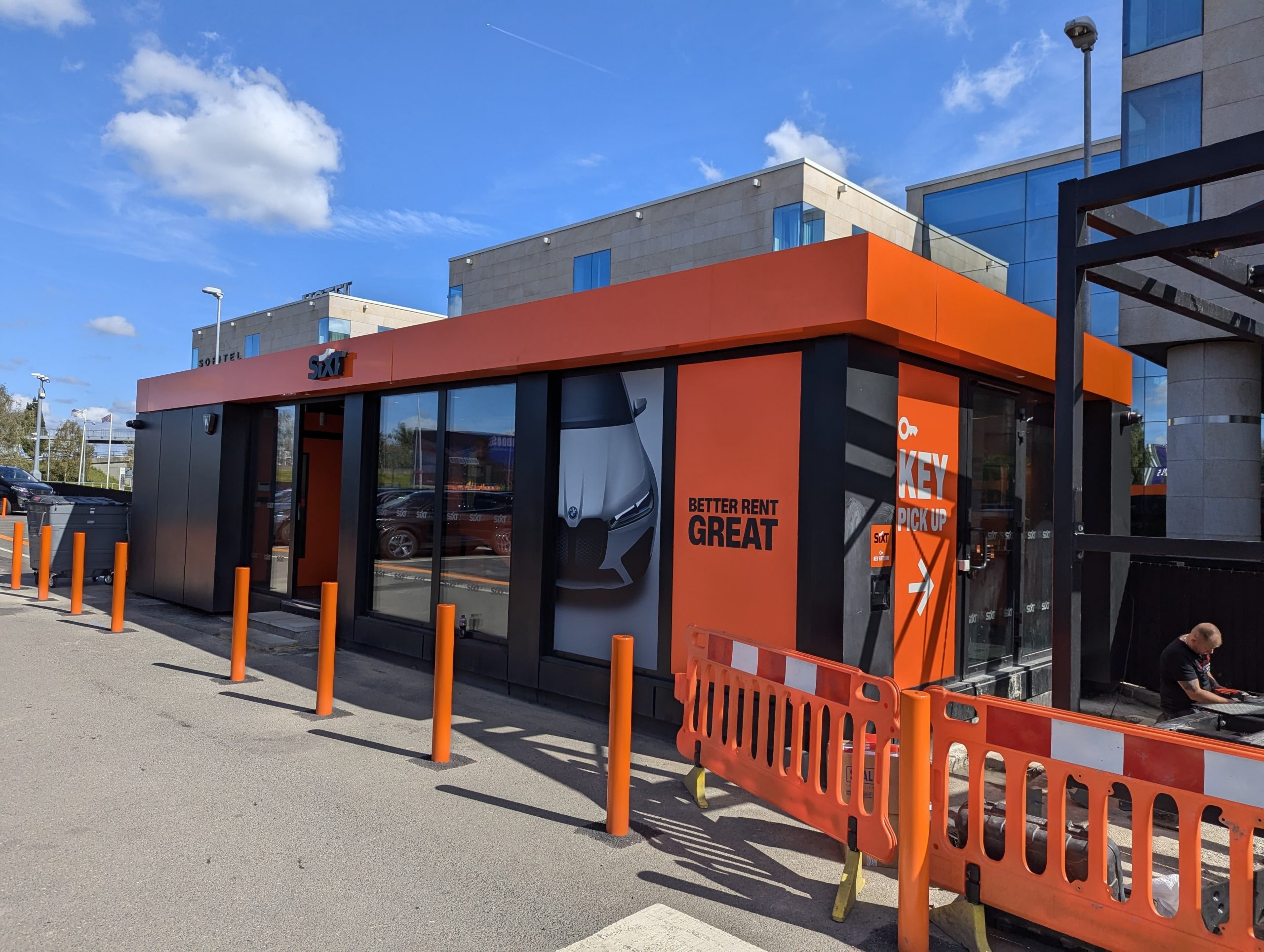 Part L compliant modular building with orange and grey cladding serving as SIXT car rental office in urban UK location