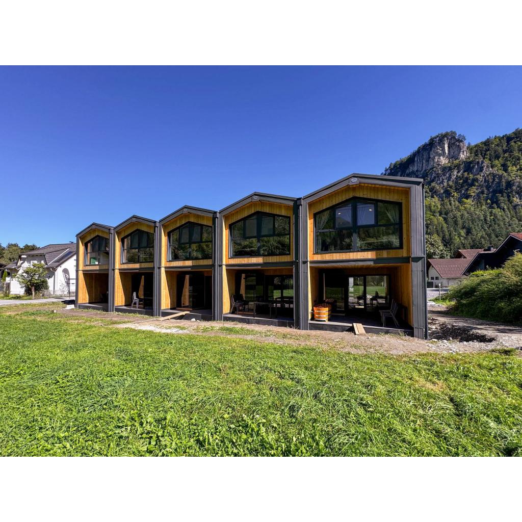 Five LARK series wooden modular homes with timber cladding and large windows in alpine mountain setting by KC Modular Buildings