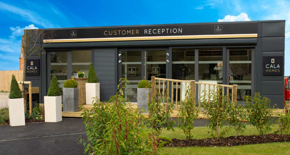 0m x 3m and 10m x 6m modular buildings UK - premium customer reception sales cabin with anthracite cladding, wooden decking, and branded signage