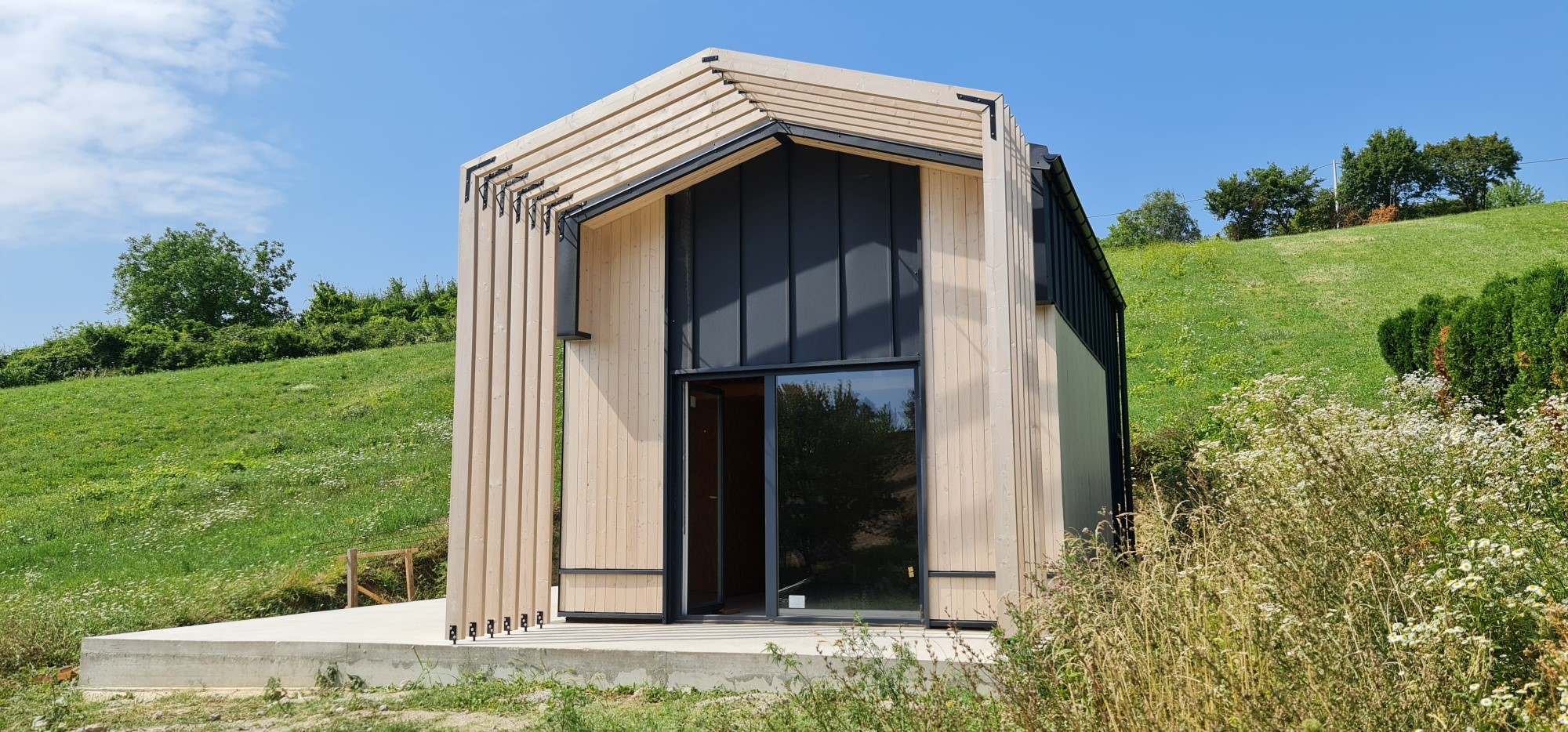 Modular garden office MTB One – modern exterior with full-height glazing in landscaped garden