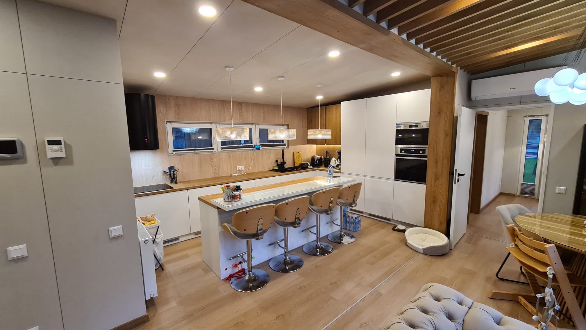 Open-plan lodge kitchen with island seating, integrated appliances, timber finishes and warm lighting
