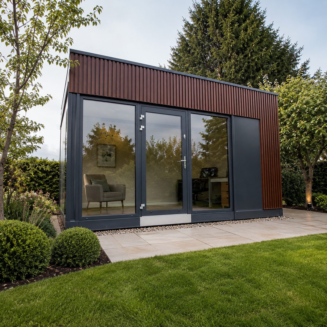 Modular insulated garden room with grey exterior large doors patio and lawn