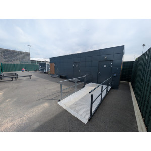 Dark-clad modular welfare unit with accessible ramp installed at St George’s Park, the FA’s National Football Centre.
