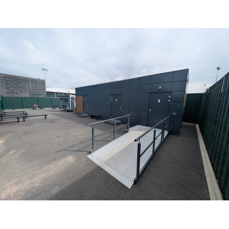 Dark-clad modular welfare unit with accessible ramp installed at St George’s Park, the FA’s National Football Centre.