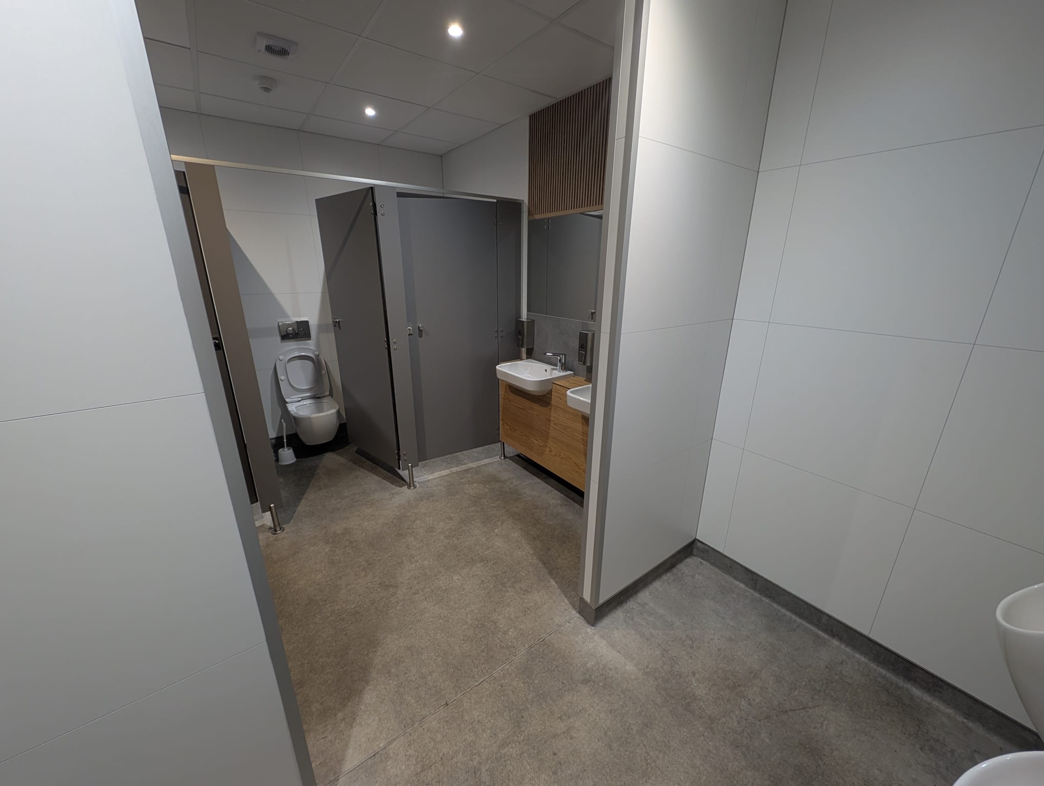 Internal washroom area with basins, wall-mounted urinals, bins and service-ready fittings.