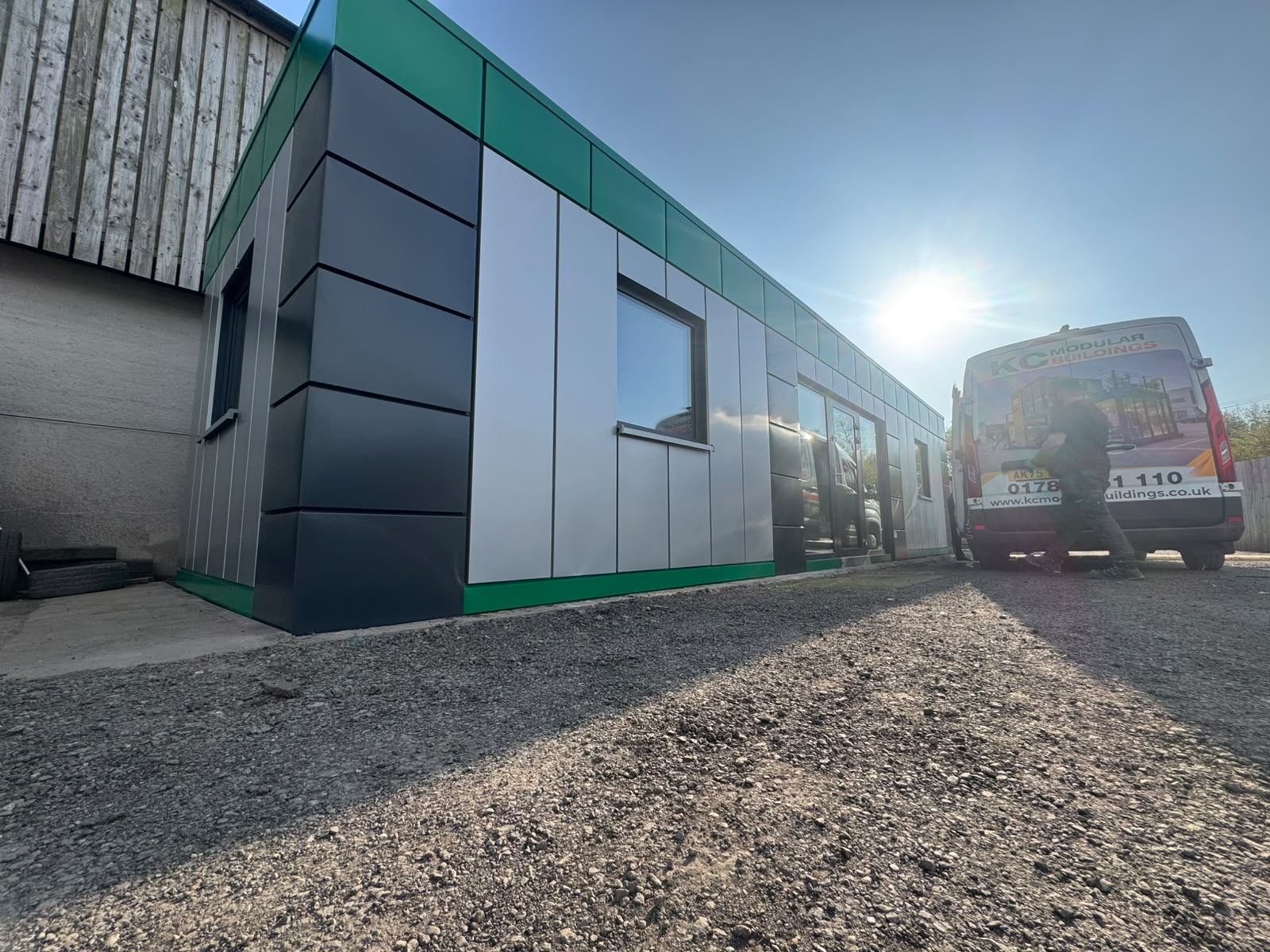 Side elevation of Excloosive Ltd insulated portable office cabin with green black and grey cladding
