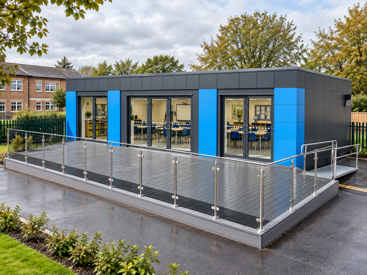 Classroom-setting building with blue accent panels, a raised terrace and a side ramp.